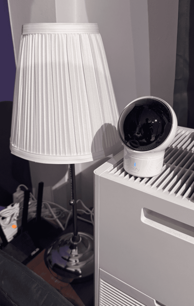 IKEA Årstid table lamp with white pleated fabric shade next to a baby monitor in a baby corner