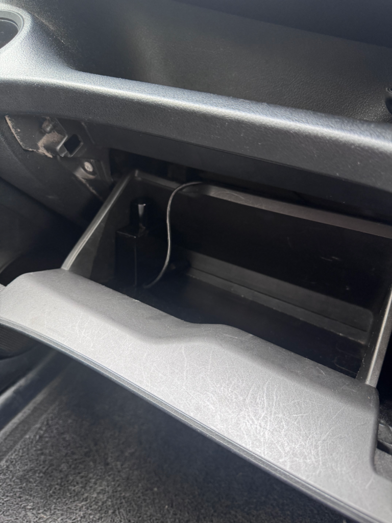 Open glove box in a Tribecar Toyota Sienta Hybrid. And a bottle of car air freshener.
